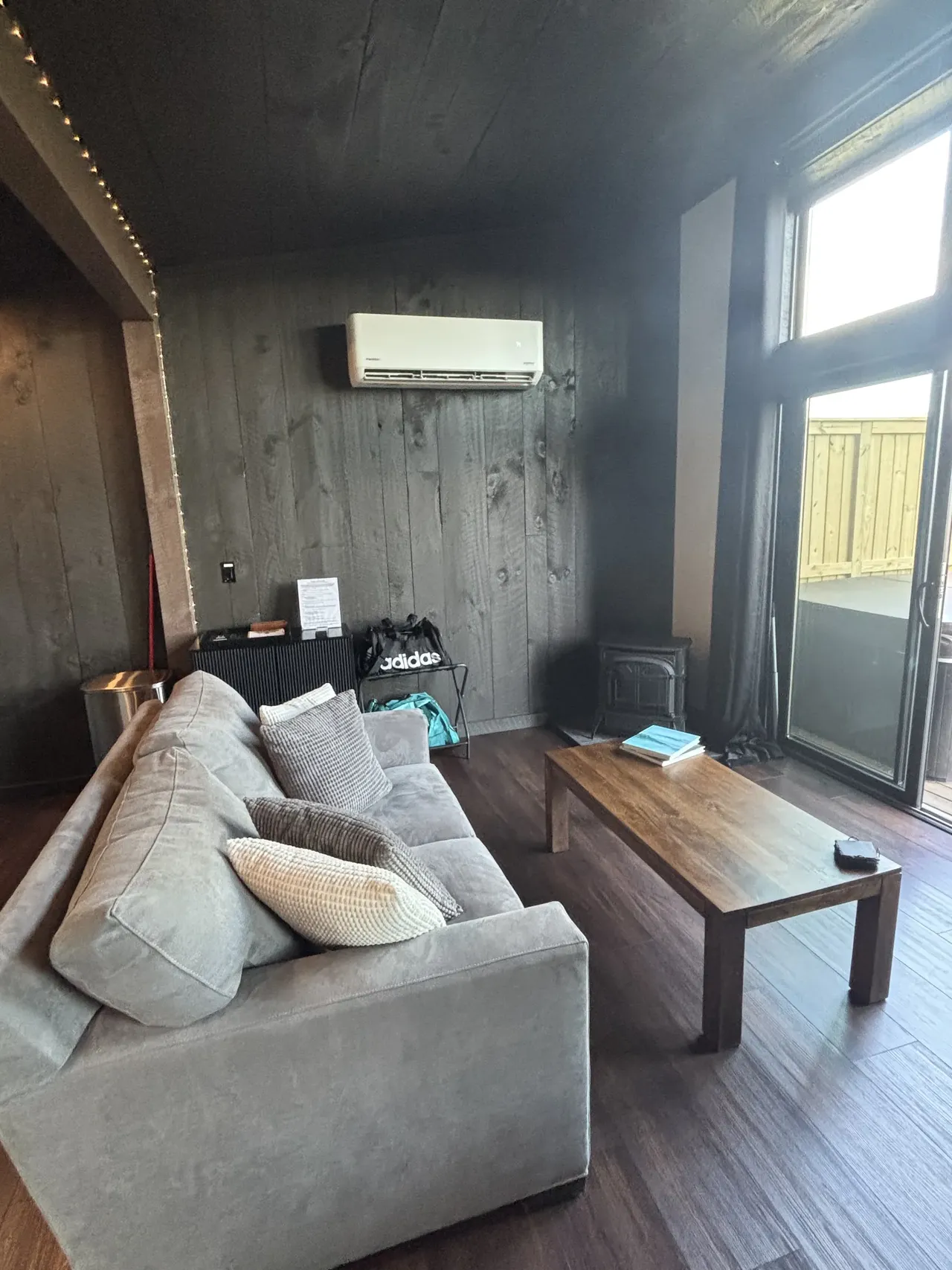 A gray sofa and wooden coffee table sit in a cabin living room.